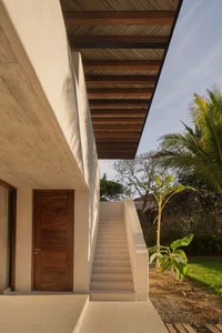 Modern house exterior with concrete stairs and wooden door.