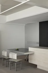 A modern interior design featuring a metallic table with minimalist chairs.