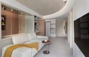 A modern living room with a white sofa, yellow throw blanket, and white floor. The space features minimalist design with clea