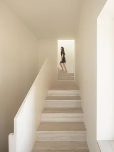A modern staircase with marble steps and railings in a minimalist setting.
