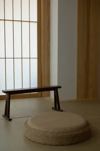 A traditional floating stool and bench made of wood and paper floor in a minimalist interior space.