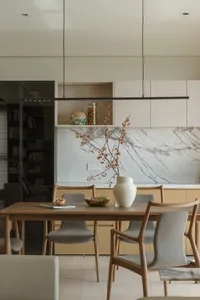 A modern residential interior featuring concrete flooring, wooden furniture, and marble accents.
