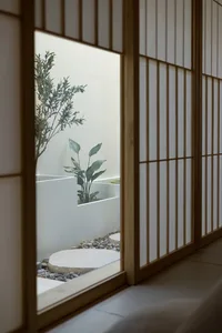 A serene indoor garden enclosed by wooden panels featuring a minimalist design with rock and plant elements.