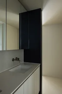 Modern bathroom with a minimalist design featuring ceramic tiles and black accents.