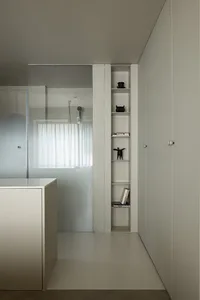 A minimalist modern bathroom with concrete shelving and a frosted glass wall.