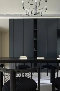 A modern living room with dark wooden and metallic furniture, featuring sleek and contemporary design elements.