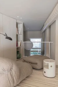 A minimalist interior design featuring neutral-toned furniture and decor.