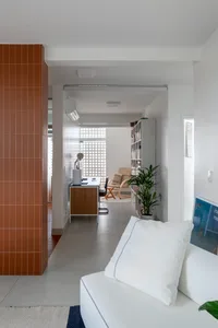 A modern home office with a tile accent wall and concrete floor.