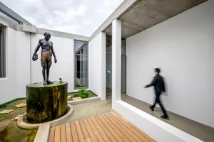 A modern interior space featuring concrete and wood materials and furniture.