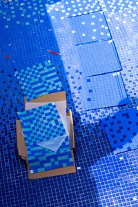 Blue floor tiles with different shades laid out in a pattern on a surface.