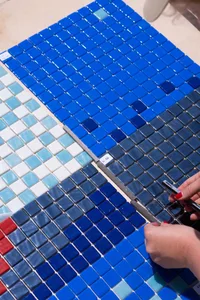 A sample layout of blue glass tiles being installed, showcasing the process and design elements used in the installation.