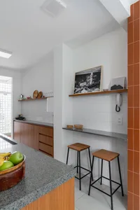 Minimalist kitchen with white tiled walls and black accents, featuring modern design elements and sleek countertops.