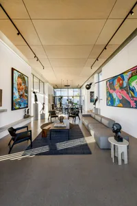 A modern-industrial living space with minimalist decor, featuring concrete flooring and walls, and contemporary furniture.