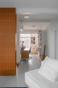 Contemporary living room featuring orange tiles and concrete flooring, minimalist design, and a cozy seating area.