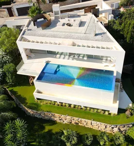A modern residential house with a concrete pool and a rooftop terrace.