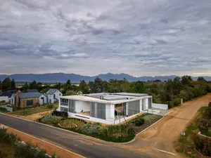 Modern house with white concrete walls and large glass windows.