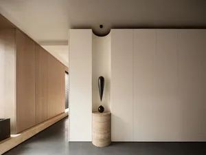 A minimalist office setup featuring a white and black desk, a black light fixture, and a controlled-lighting system.