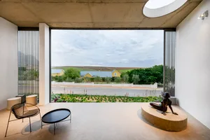Minimalist residential interior with concrete, glass, and metal elements.