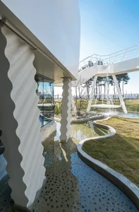 An exterior view of a modern landscape featuring concrete and glass elements.