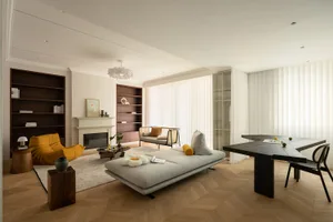 A contemporary living room with a timber floor, featuring modern furniture, a fireplace, and bookshelves.