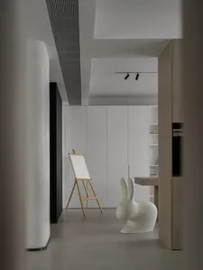 A minimalist art studio featuring a floating wooden table and white panels