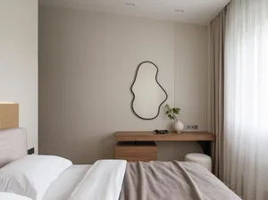 A minimalist bedroom with neutral tones and simple, modern furniture.