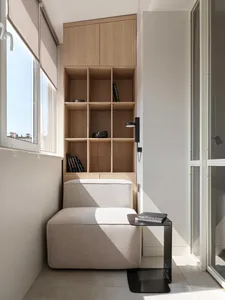 A minimalist living room featuring a wooden cabinet with shelves.