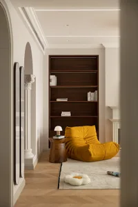 A minimalist living room featuring wooden furniture and a yellow lounge chair.