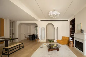 A modern living room with wooden floors, plaster walls, and ceramic accents.