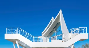 Modern minimalist house with glass walls and a geometric design.