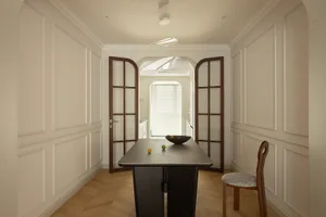 A modern residential entryway featuring wooden furniture and a glass panel door.