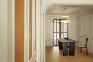 Modern minimalist dining room with wooden and metallic elements.