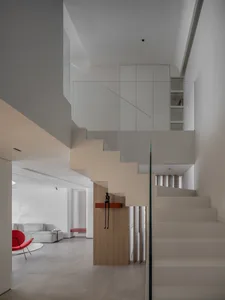 A modern apartment interior featuring concrete stairs and a minimalist design.