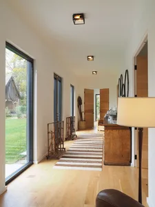 Modern interior corridor featuring hardwood flooring and large windows