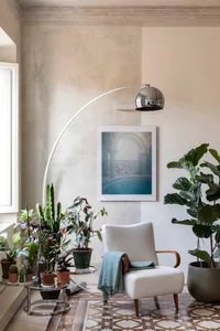 A modern living room featuring comfortable seating, plants, and concrete accents.