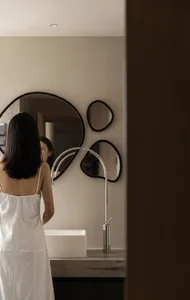 A minimalist bathroom with a ceramic sink, stainless-steel faucet, and modern design elements.