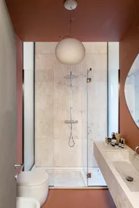 Modern bathroom with marble tiles and a spherical light fixture.