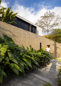 Modern house with wooden fence and lush greenery.