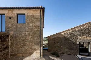 Modern residential interior with stone walls and large windows.