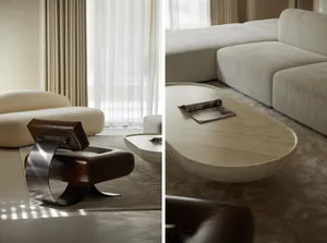 Modern marble coffee table and lounge chairs in a living room setting.