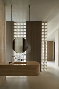 A modern minimalist bathroom featuring a marble sink and wooden accents.