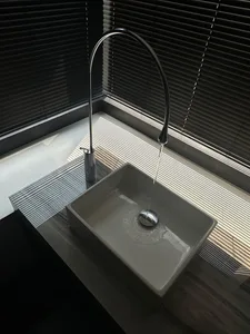 A sleek, minimalist bathroom sink with a ceramic basin and a modern faucet.
