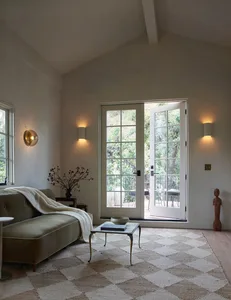 A minimalist living room with a metal coffee table on a white and beige floor, featuring a road-themed design and a view of t