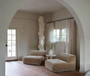 A modern living room featuring beige fabric furniture and light-colored wooden flooring.