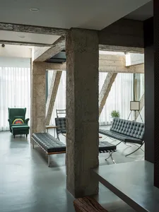 Modern industrial office lounge featuring concrete elements and minimalist furniture.
