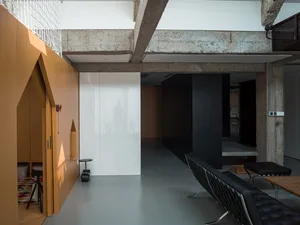 Industrial-style living area with exposed concrete ceilings and wooden elements.