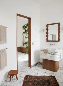 Minimalist bathroom interior featuring a marble sink and wooden accents.