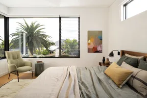 A minimalist bedroom featuring wood, fabric, and metal elements.