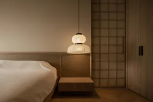 Minimalist bedroom with wooden paneling, floating nightstand, and a serene, cozy atmosphere