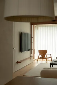 A modern minimalist living room featuring wooden furniture and minimalistic decor.